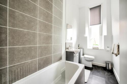 格拉斯哥Two Bed Stylish Apartment in Heart of West End的带浴缸、卫生间和盥洗盆的浴室