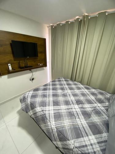 卡贝德卢Flat Siberian 100m do mar的一间卧室设有一张床和一个带电视的窗户。