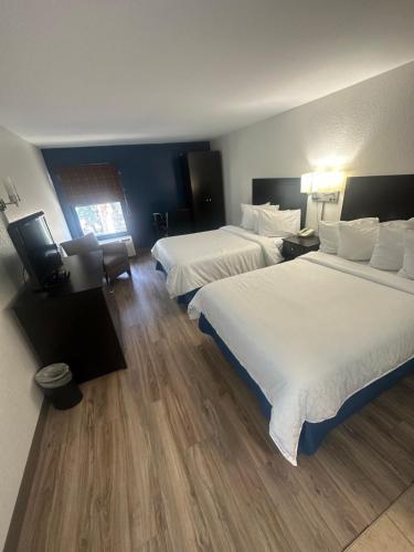坦帕Brandon Center Hotel的酒店客房设有两张床和电视。