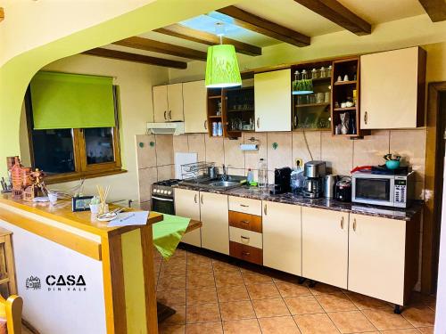 米奥修德萨斯Casa din Vale的厨房配有白色橱柜和绿色天花板
