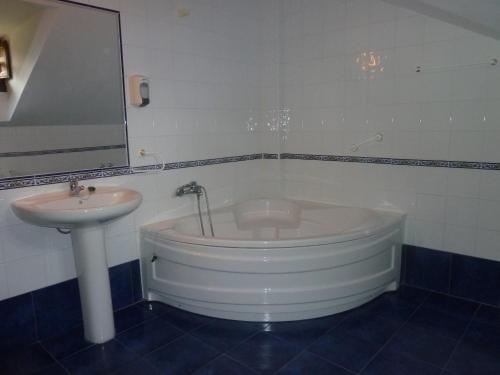 索托德卢伊尼亚Hotel Apartamentos La Hortona的带浴缸和盥洗盆的浴室