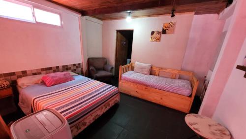 伊瓜苏港Hostel Haus的一间小卧室,配有两张床和椅子
