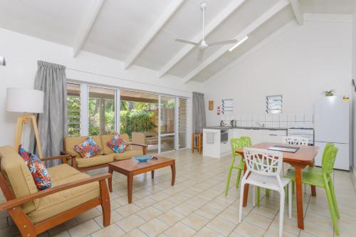 拉罗汤加Rarotonga Daydreamer Escape的厨房以及带桌椅的起居室。