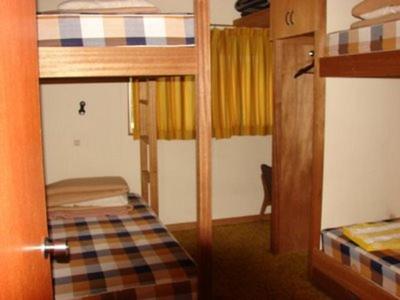 关市STI SKI LODGE的小房间设有两张双层床和一扇门