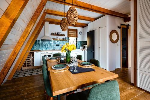 RakovacForrest Relax & Spa的厨房配有带绿色椅子的木桌
