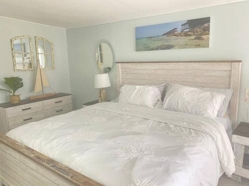 大松礁岛key Deer Retreat/direct gulf access/hot tub的一间卧室配有一张带两面镜子的大型白色床