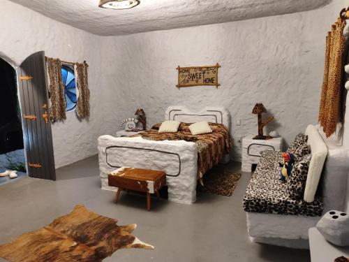 布埃诺布兰当Casa dos Flinstones, Vila Mágica的白色卧室配有床和沙发