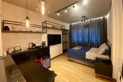 特雷索波利斯Loft lindo e aconchegante no centro de Teresópolis的一间卧室配有一张床和一张带水槽的书桌
