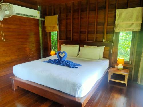 阁遥岛Sabai House Bungalow的一间卧室配有一张带蓝色丝带的床