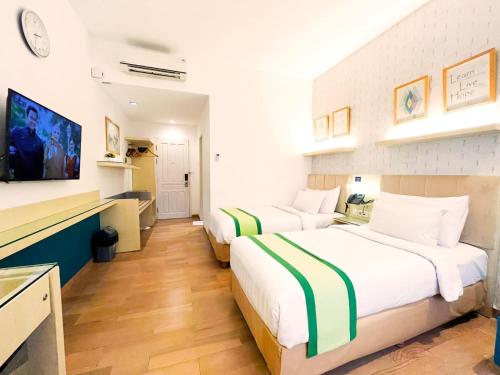 普禾加多Hotel Wisata Niaga Campus的一间酒店客房,设有两张床和电视