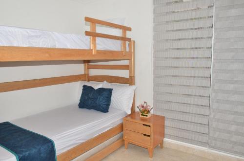 吉拉尔多特Casa Vacacional con Jacuzzi en Girardot Cundinamarca的一间卧室设有两张双层床和床头柜。