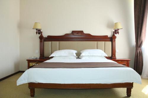 苦盏菲鲁兹酒店的卧室配有一张带白色床单和枕头的大床。