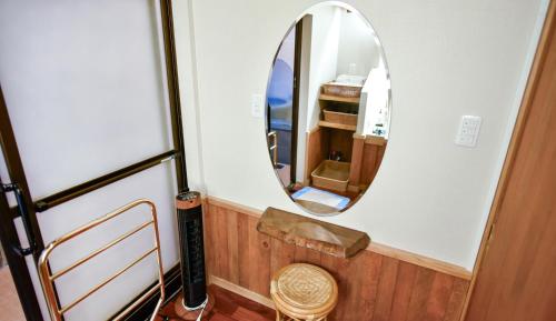 别府Kamegawa Onsen HATAGO Yuyu的一个小房间,配有镜子和椅子