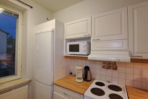 耶姆赛Yksiö lähellä Himosta.的厨房配有白色橱柜和白色微波炉