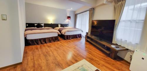 由布市Resort Yufuin - Grandpia Resort Yufuin的一间卧室配有两张床和一台平面电视