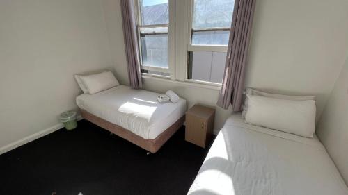凯阿玛Beachside Budget Rooms的小房间设有两张床和窗户