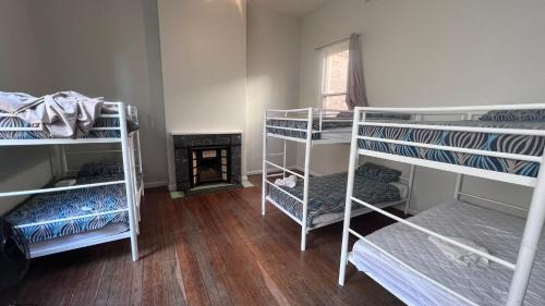 凯阿玛Beachside Budget Rooms的客房设有三张双层床和壁炉。
