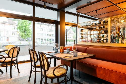 图恩Hotel Aare Thun的餐厅设有桌椅和窗户。