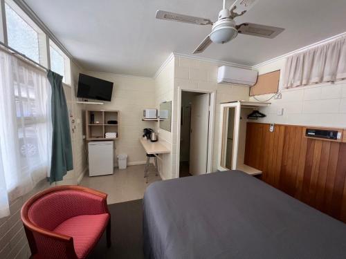 WinkieGlossop Motel的一间卧室配有一张床、一把椅子和一张书桌