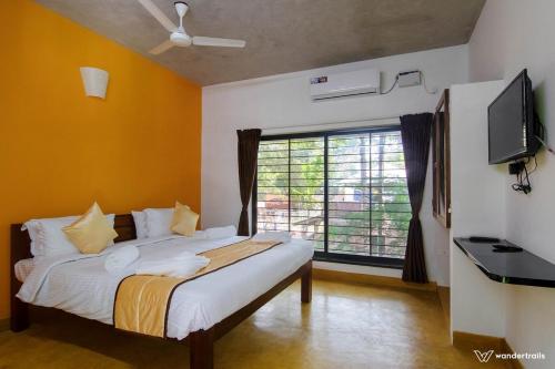 黎明之村Paradise Le Tamarin的一间卧室设有一张带电视和窗户的床。