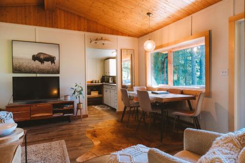 纳卡斯普Kootenay Lakeview Retreats - Forest Cabin的客厅配有餐桌和电视