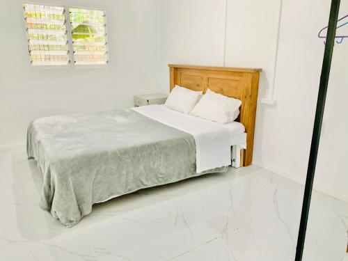 FolahaTonga Cottage - Private Double Room Shared Facility的白色卧室配有白色床单