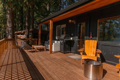 纳卡斯普Kootenay Lakeview Retreats - Forest Cabin的遮蔽在房子的门廊上,有甲板