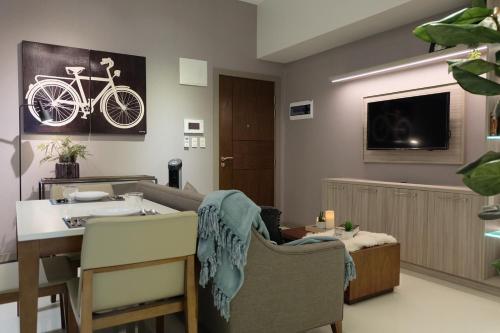 马尼拉One Uptown Residence的客厅配有桌子和墙上的自行车
