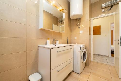 伦Apartments Zora的浴室设有白色洗衣机和烘干机。