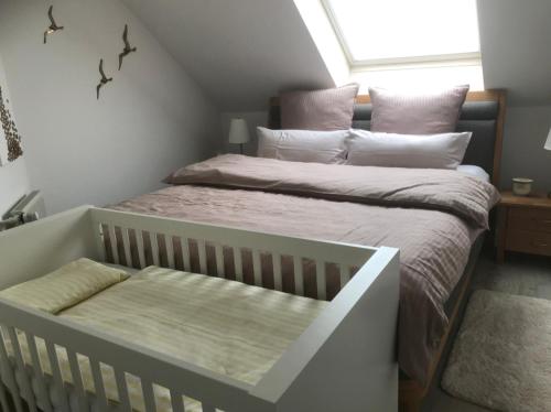 克洛彭堡Wohnung mit Whirlpool, Nähe Thülsfelder Talsperre的一间卧室配有一张带婴儿床的床