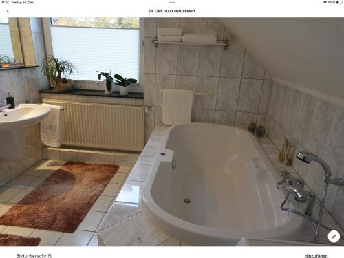 克洛彭堡Wohnung mit Whirlpool, Nähe Thülsfelder Talsperre的浴室配有大型白色浴缸和水槽