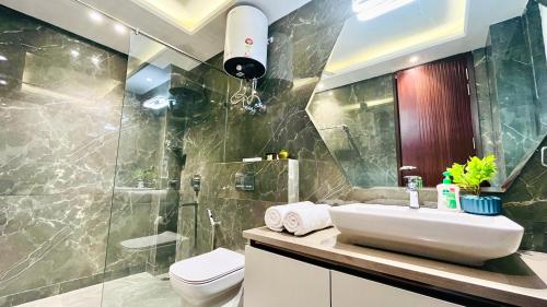 古尔冈Olive Service Apartments - DLF Cyber City的一间带水槽、卫生间和淋浴的浴室
