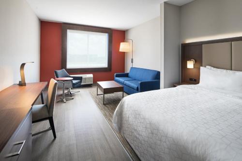 拉伯克Holiday Inn Express & Suites Lubbock Central - Univ Area, an IHG Hotel的酒店客房,配有一张床、一张桌子和椅子