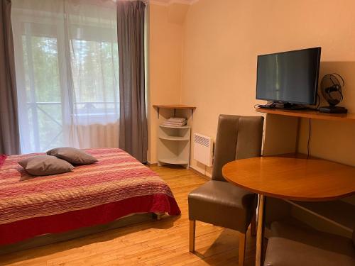 瓦尔米耶拉百里酒店的配有床、桌子和电视的房间
