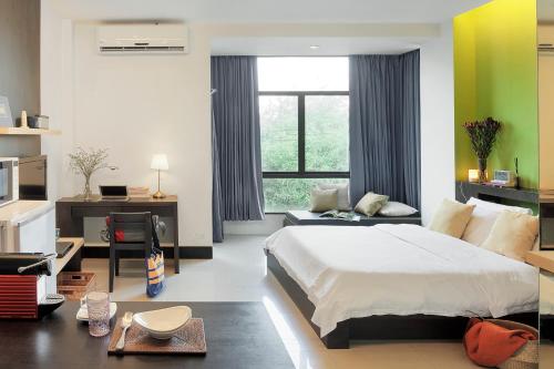 曼谷@Home Residence的一间卧室配有一张床、一张书桌和一个窗户。