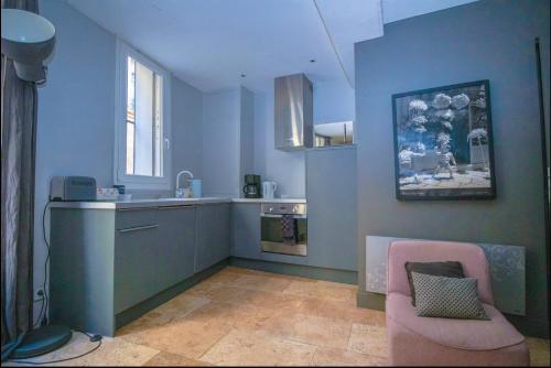 蒙彼利埃卡巴内尔公寓 的厨房拥有蓝色的墙壁和粉红色的椅子