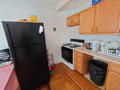 布鲁克林Fawlty Towers的厨房配有黑色冰箱和炉灶。