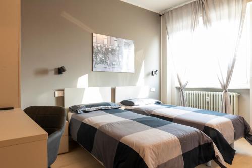 阿斯蒂Arò Design Suite的一间卧室设有两张床、一张沙发和一个窗口