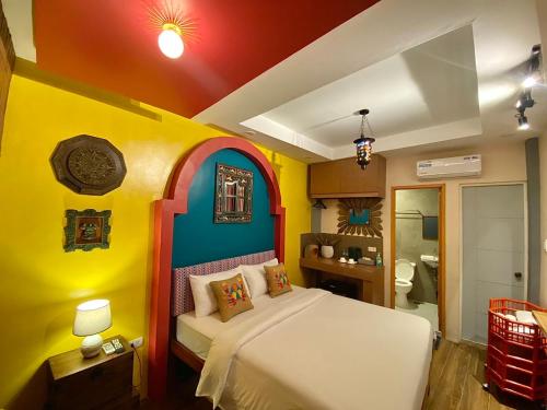 马尼拉Rain Airport Bed and Breakfast的色彩缤纷的客房里设有一间卧室和一张床