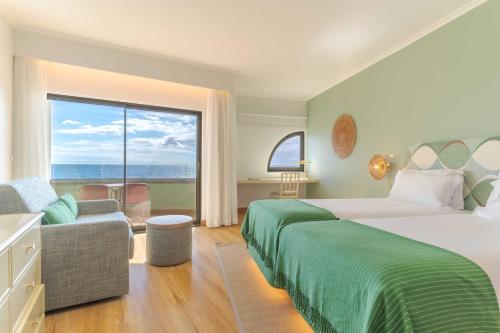 丰沙尔Pestana Vila Lido Madeira Ocean Hotel的一间卧室设有一张大床和一个大窗户