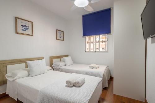 莫特里尔Villa Torres Motril的客房设有两张床和窗户。