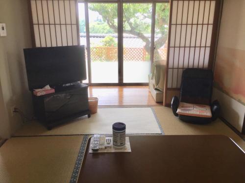 由布市天ゆふ(Ten Yufu)的客厅配有电视和带遥控器的桌子。