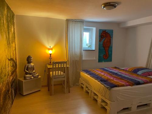 朗根费尔德Shrinath Yog Temple的一间卧室配有一张床、一张桌子和一尊雕像
