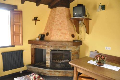 PradoCasa rural "Matela"的客厅设有壁炉,楼上配有电视