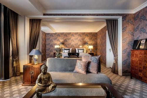 不莱梅Parkhotel Bremen – ein Mitglied der Hommage Luxury Hotels Collection的卧室配有一张床,房间内设有雕像