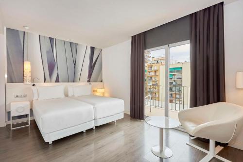 巴塞罗那NH巴塞罗那体育场酒店的白色卧室配有白色的床和椅子