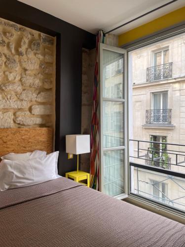 巴黎Hôtel Prince de Conti的一间卧室设有一张床和一个大窗户