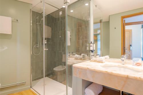 丰沙尔Pestana Vila Lido Madeira Ocean Hotel的一间带玻璃淋浴和水槽的浴室