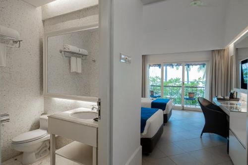秾莎农萨海滨度假村的一间带卫生间、水槽和床的浴室