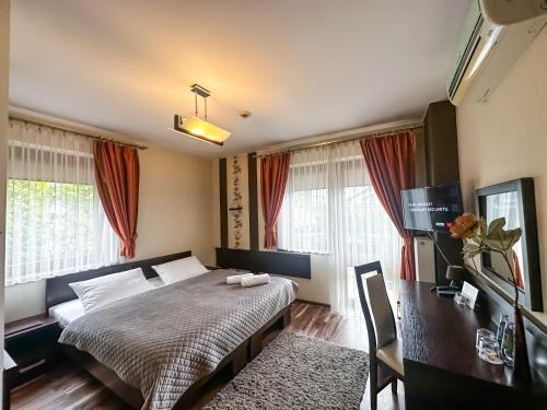 热舒夫梅什科酒店的卧室配有一张床、一张书桌和窗户。